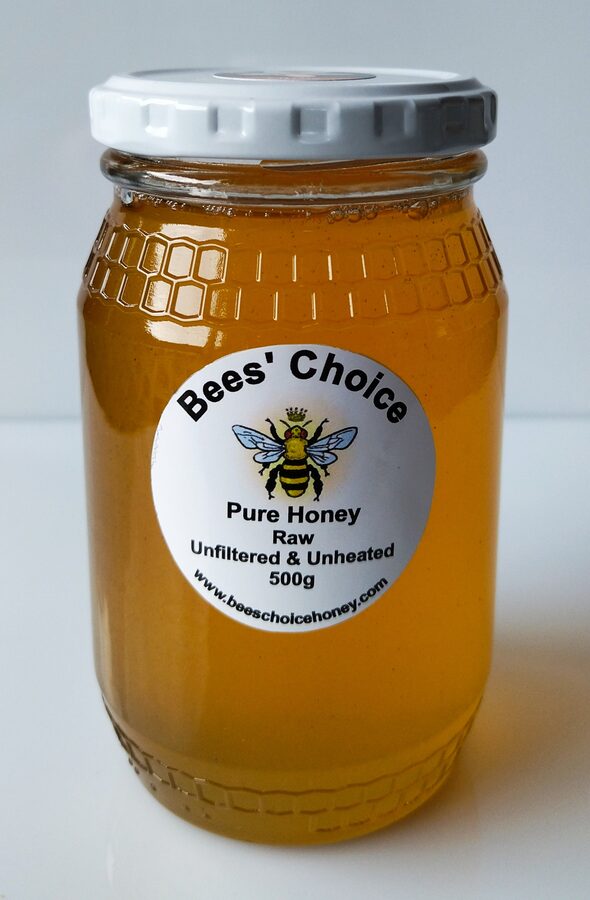 A glass jar of Bees' Choice raw honey with an embossed honeycomb pattern